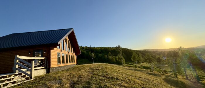 Dow and Duggan log home on rural land at sunset